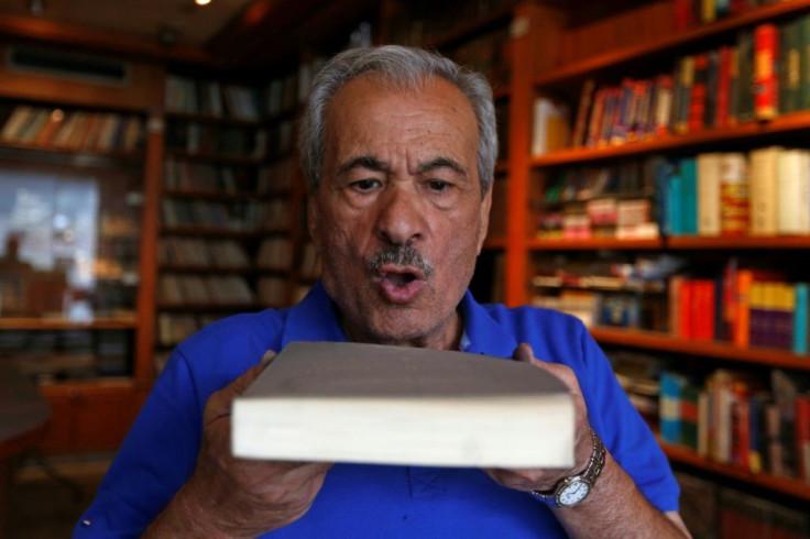 Muhammad Salem al-Nouri blows dust off a book at the Dar al-Maarifa library, which was forced to close in 2000 because of poor sales and growing costs