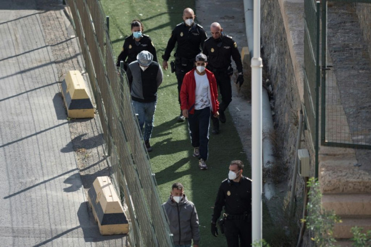 Police escort newly-arrived migrants to a Centre for Temporary Assistance for Foreigners (CATE) in Almeria