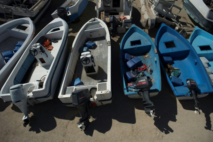 Small boats used by migrants to cross sea are stored in an open-air warehouse in Almeria