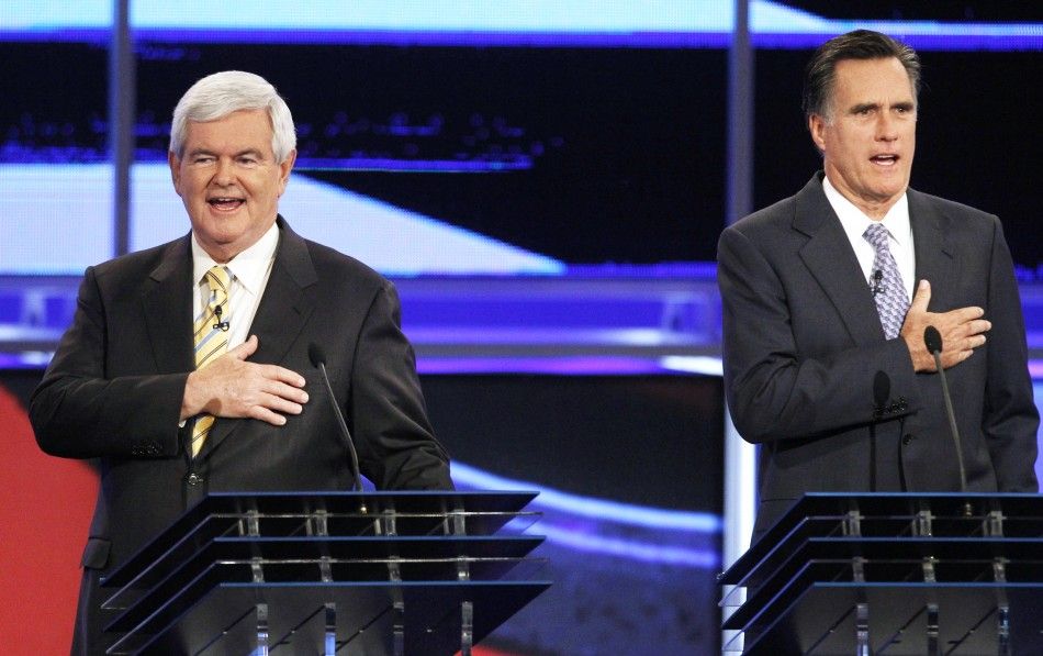 Republican presidential hopefuls Gingrich and Romney put their hands on their hearts for the national anthem before the first New Hampshire debate of the 2012 campaign in Manchester