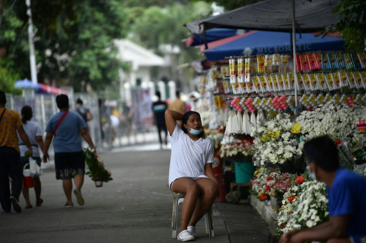 Flower vendors wait for customers near a Manila cemetery