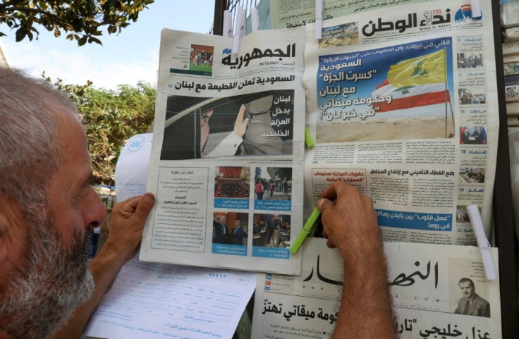 A Lebanese vendor arranges newspapers, bearing headlines of the diplomatic row with Saudi Arabia, at his stall in the capital Beirut on Saturday