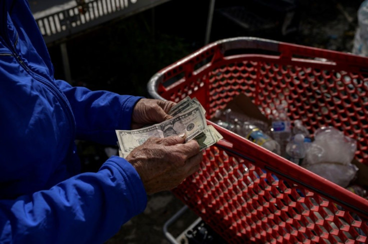 A "canner" counts the dollar bills he gets for recycling bottles and cans in New York City