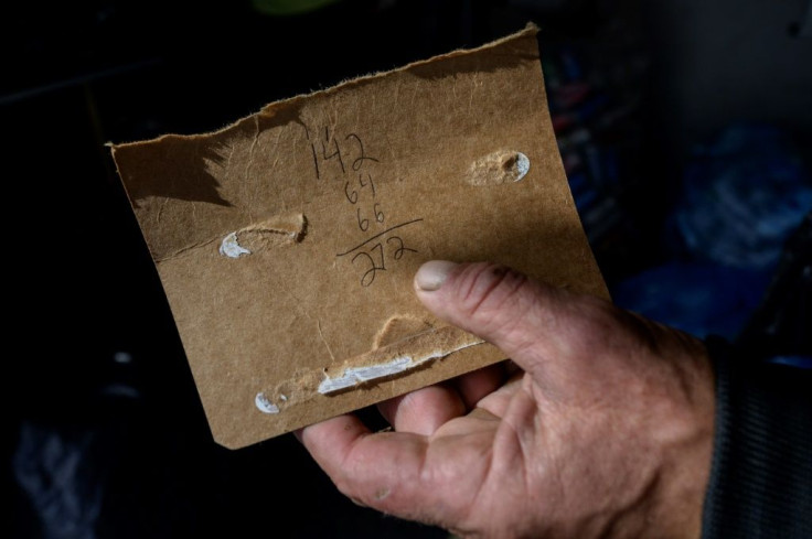 The number of bottles ad cans that a "canner" exchanges at a recycling center is written on a piece of paper on October 18, 2021