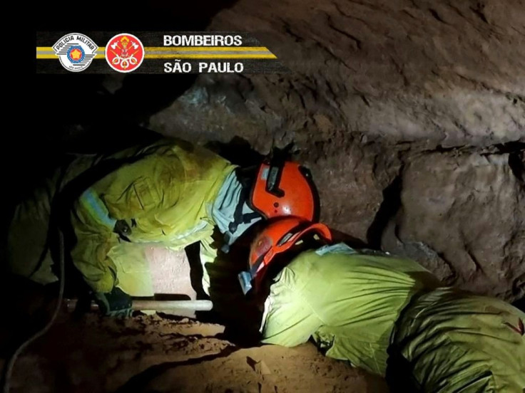 A handout picture released from Sao Paulo state's Military Police shows firefighters working to rescue other firefighters buried in a cave after a collapse near the Brazilian city of  Altinopolis