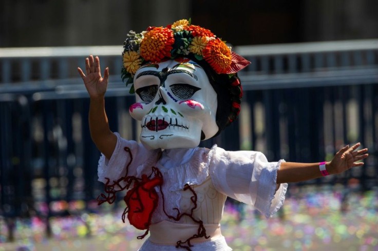 A woman takes part in a Day of the Dead parade in Mexico City, where an easing of the pandemic led to the return of public celebrations