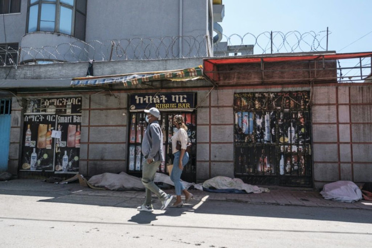 People walk in front of closed shops in Addis Ababa on October 21, 2021 amid war in the northern Tigray region