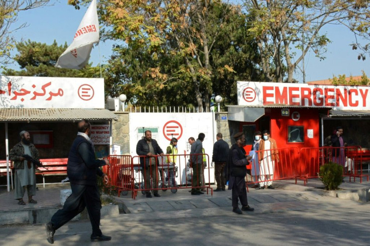 Afghan medical staff members (C) stand at the entrance of a hospital as they wait to receive the victims of blasts in Kabul on November 2, 2021, after Afghanistan's capital was hit by two blasts near a military hospital