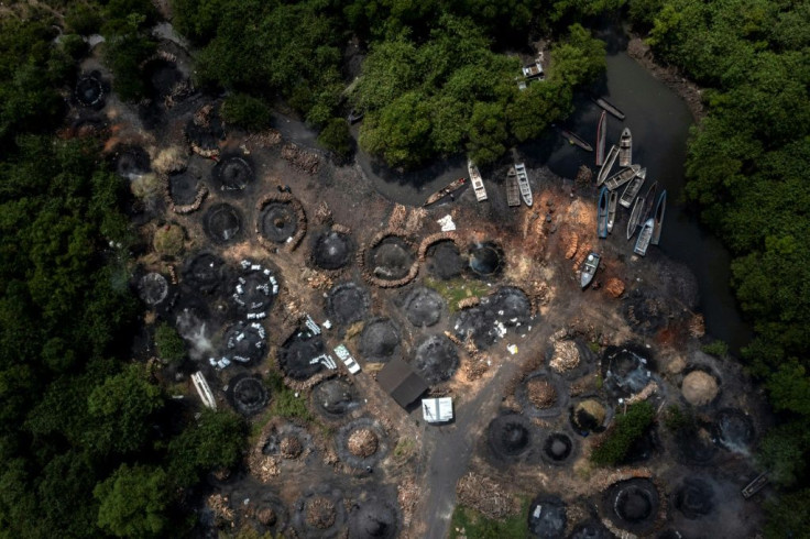 Charcoal production happens near the port, in an area dotted with pyramid-shaped pyres smouldering like small volcanos