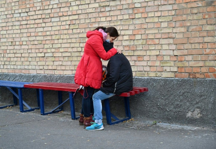 Grieving relatives comfort each other outside Kiev's Hospital Nuber Four