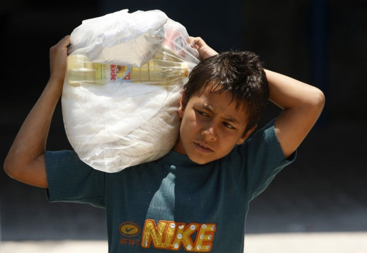 A Palestinian boy carries a sack of food supplies at a U.N food distribution Center in Gaza City