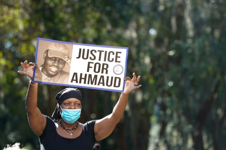 Beverly Green with the Transformative Justice Coalition demonstrates outside  the Glynn County Courthouse during jury selection for the three men charged with the shooting death of Ahmaud Arbery