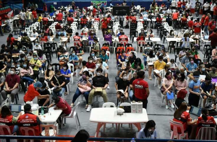 Teenagers wait for their coronavirus vaccine at a stadium in Manila