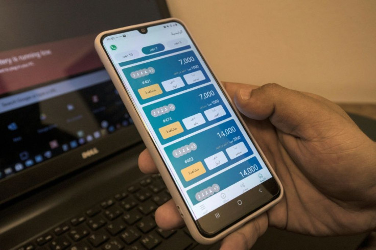 An employee of "Al-Gameya", a tech startup for money-pooling, holds a phone with the application at the company offices in Egyptâs capital Cairo