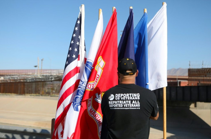 Ivan Ocon, a US army veteran deported to Mexico, places US flags by the border wall in Ciudad Juarez in the hope of being allowed to return