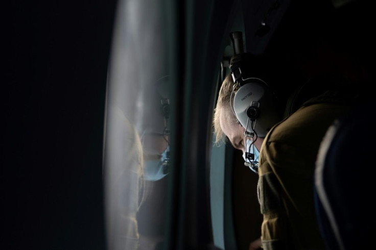French crew sit next to the plane's windows, scanning the ocean surface for suspicious activity