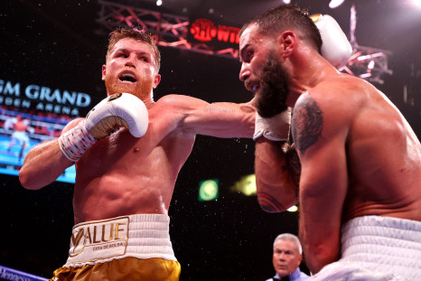 Canelo Alvarez (L) punches Caleb Plant during their championship bout for Alvarez's WBC, WBO and WBA super middleweight titles and Plant's IBF super middleweight title at MGM Grand Garden Arena