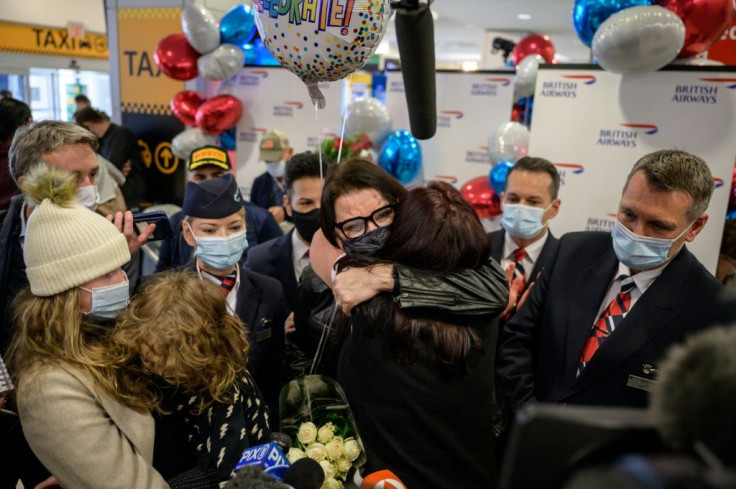 Members of the Erebara family embrace after arriving at JFK international airport in New York on a flight from the UK, following the easing of pandemic travel restrictions that kept them all apart for months