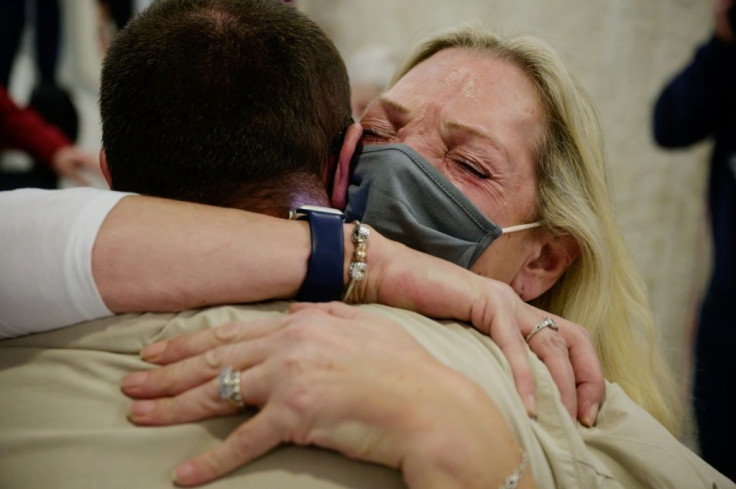 Alison Henry embraces her son Liam as they meet after arriving on a flight from the UK, following the easing of pandemic travel restrictions at JFK international airport in New York on November 8, 2021