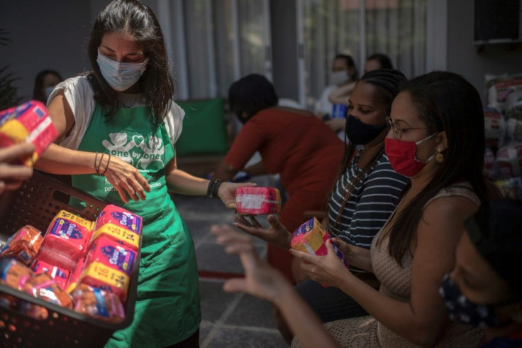 A worker of the NGO One By One gives sanitary pads to mothers and other relatives of children with special need