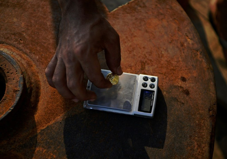 In this photo taken in 2019, an illegal gold miner weighs a small lump of gold on his boat in a river in the Amazon basin, south of Porto Velho -- Brazil mined 107 tonnes of gold in 2020, making it the world's seventh-biggest producer