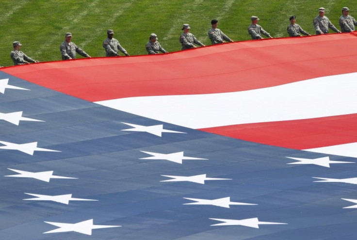 Military personnel open a giant American flag before the Indianapolis 500 auto race in Indianapolis