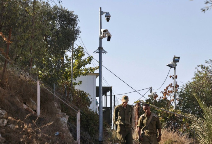 Israeli soldiers walk past surveillance cameras in Hebon, the only Palestinian city with Jewish settlers living inside it