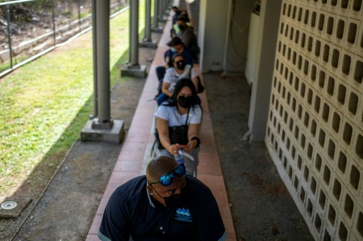People wait to be inoculated with the Moderna vaccine at a Puerto Rico National Guard vaccination center on the island of Vieques in March 2021