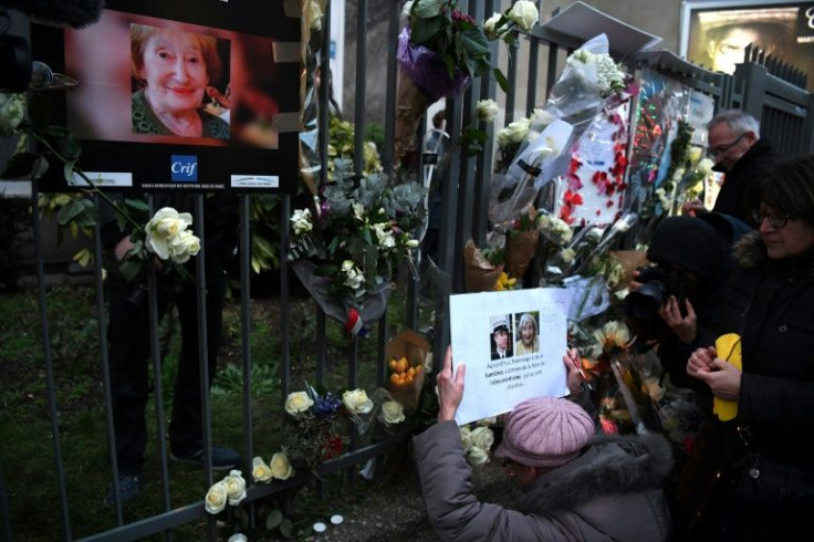 A woman holds a photograph of Mireille Knoll on March 28, 2018, after taking part in a march in Paris in memory of the 85-year-old Jewish woman murdered in her home in an attack that caused an outcry over anti-Semitism in France
