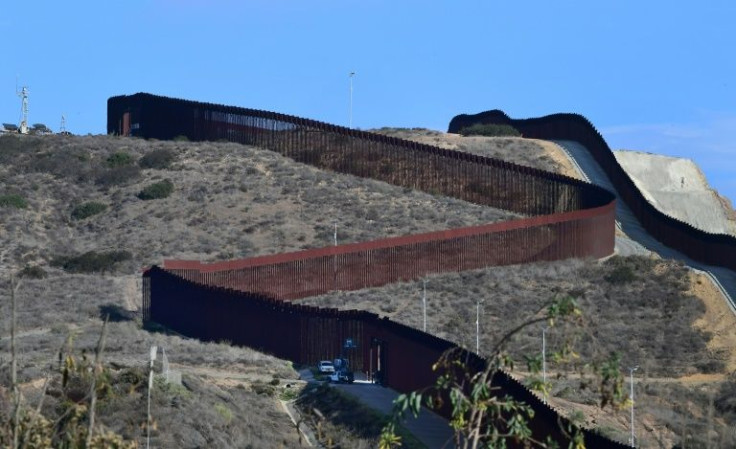 US Border Patrol vehicles are seen parked beside a gate on the US-Mexico border in Imperial Beach, California in November 2021