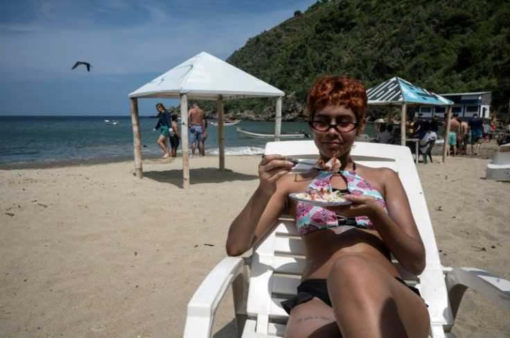 A tourist eats ceviche prepared with lionfish on the beach of Chichiviriche de la Costa, Vargas state, Venezuela