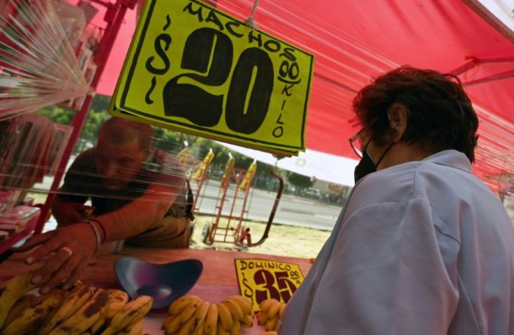 A woman buys fruit at a market in Mexico City, where inflation is making life tougher for many despite an economic recovery