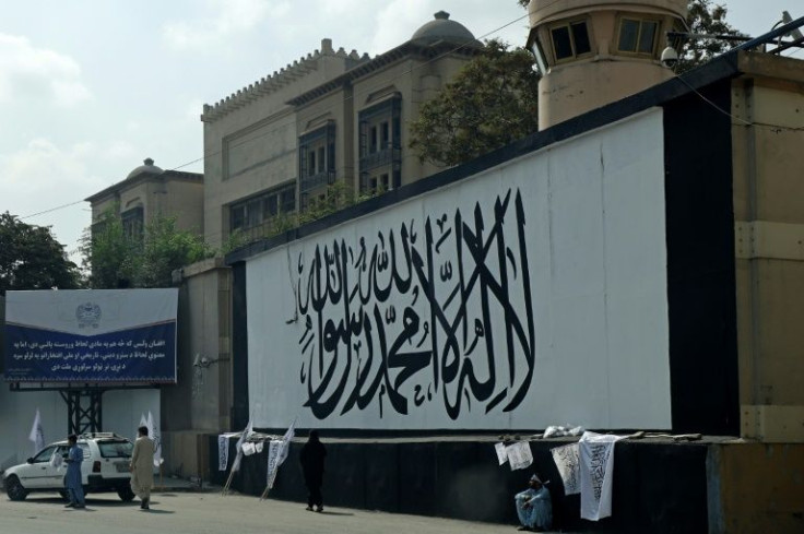 Vendors sell Taliban flags in front of a wall alongside the shuttered US embassy in Kabul in September 2021