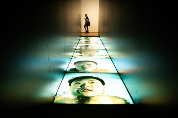 A woman looks at 1/30th of a Second Underwater by Wang Wei on the opening day of the M+ art museum in Hong Kong