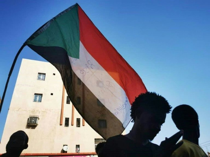 A file picture taken on November 4, 2021 shows youths waving Sudan's flag as they protest in the streets of the capital Khartoum