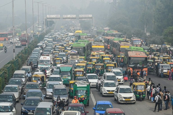 Commuters make their way along a busy road under heavily smoggy conditions in New Delhi