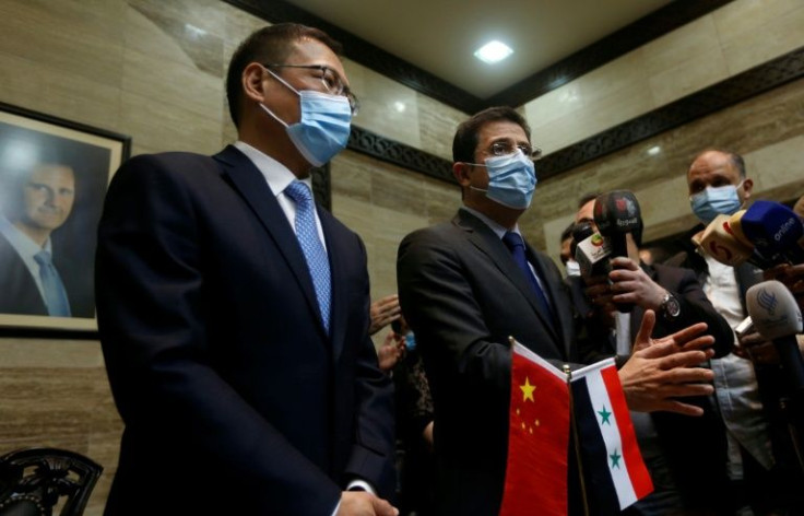 Syrian Health Minister Hassan al-Ghabash (R) and Chinese ambassador Feng Biao (L) take part in a ceremony upon the arrival of Sinopharm Covid-19 vaccine doses, in the capital Damascus