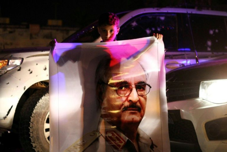 A boy holds a portrait of Libya's General Khalifa Haftar