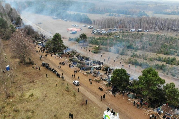 Migrants collect their belongings before leaving a camp on the Belarusian-Polish border