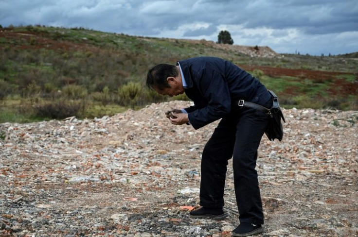 Environmental activist Zhang Zhengxiang holding rocks that he says are polluted at an area which used to be a cement factory construction site near Dian Lake in Kunming, in southwestern China's Yunnan province
