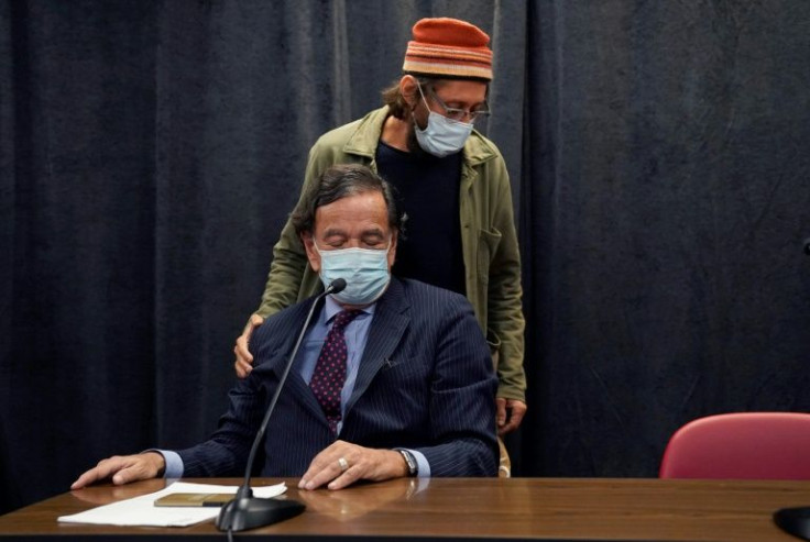 US journalist Danny Fenster puts his hand on the shoulder of former US diplomat Bill Richardson, who helped negotiate his release from a prison in Myanmar