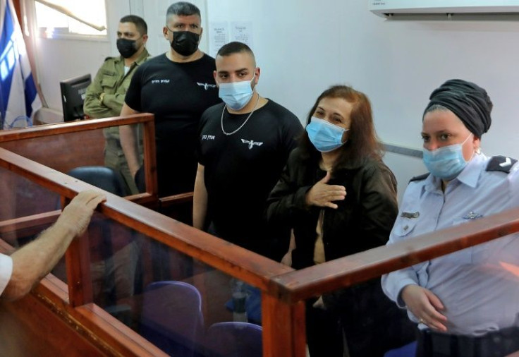 Spanish aid worker Juana Rashmawi appears in the dock flanked by Israeli police officers as she is sentenced to 13 months in prison on charges of illegally funding a Palestinian militant group