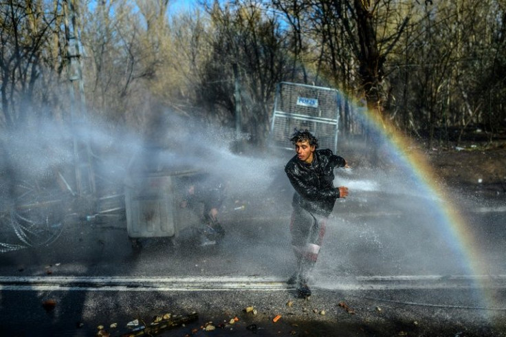 Greek police use water cannons in an attempt to prevent migrants from crossing the border from Turkey in March 2020
