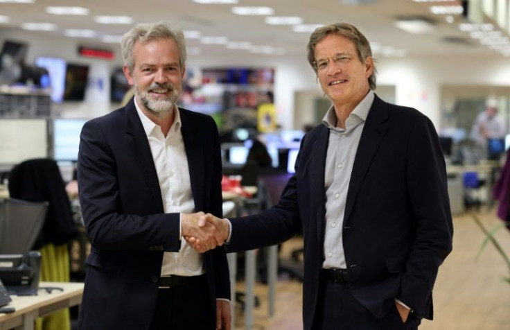 Google's Sebastien Missoffe (left) and Fabrice Fries reach what the AFP CEO described as a 'pioneering' agreement for the search giant to pay for the news agency's content