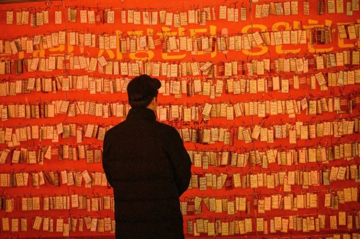 A man looks at name cards wishing success to students sitting South Korean's national university entrance exam at the Jogyesa temple in Seoul