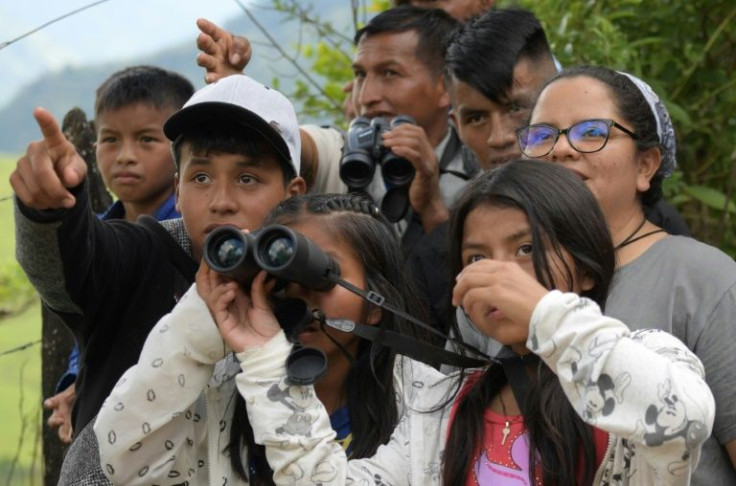 Indigenous people and children of former FARC guerrillas use binoculars to watch birds at a lookout in Planadas