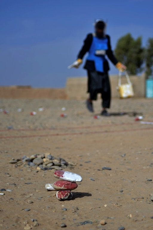 Deminers are using rocks painted red and white to signal to children where it is safe to play -- and where mines are buried