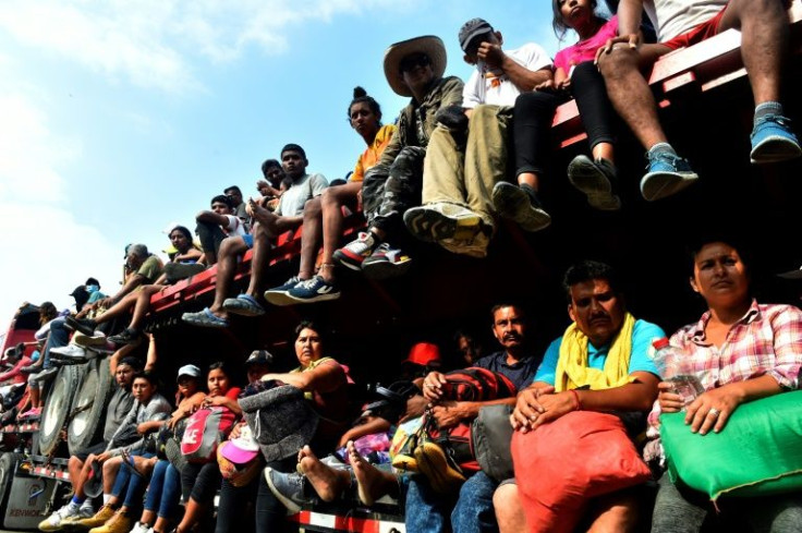 Migrants traveling in a caravan through southern Mexico hitch a ride on a truck in the state of Veracruz