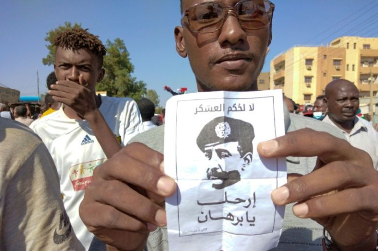 A Sudanese anti-coup protester holds a poster depicting top general Abdel Fattah al-Burhan and reading: "No to Military Rule"