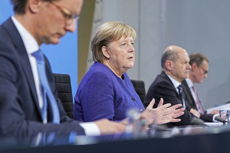 German Chancellor Angela Merkel (2nd L), North Rhine-Westphalia's State Premier Hendrik Wuest (L) German Finance Minister and candidate for Chancellor Olaf Scholz (2nd R) and Berlin Mayor Michael Mueller (R) address a press conference following a video me
